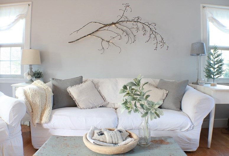 branches with fairy lights over couch in living room