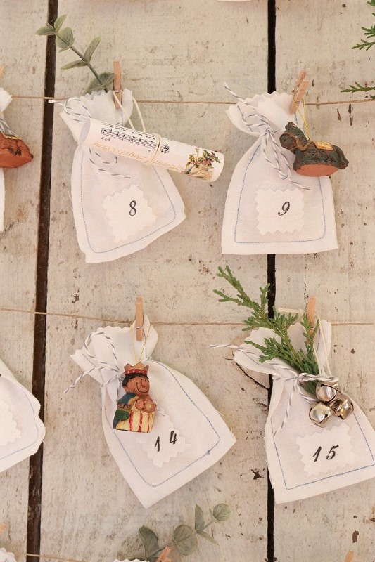 Make this easy DIY Advent Calendar by hanging mini muslin bags and ornaments.  The bags are easy to sew to count down Advent!   #adventcalendar #christmascalendar