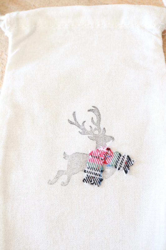 Make these Farmhouse Christmas gift bags! Stamp muslin bags, and embellish with flannel fabric.  Stuff with Christmas goodies! #christmasgiftbag #farmhousechristmas