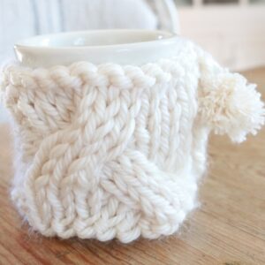 Keep your mug warm this winter with this cable knit mug cozy. This free knit pattern show you how to make this sweet mug warmer | mug sweater | mug cozy. Cheers to hot tea and coffee! #mugcozy #mugwarmer #mugsweater