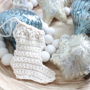 Here's a simple crochet pattern for a mini Christmas stocking ornament. Hang it on the tree or make several for a Christmas garland! #freecrochetpattern #crochetornament #crochetstocking
