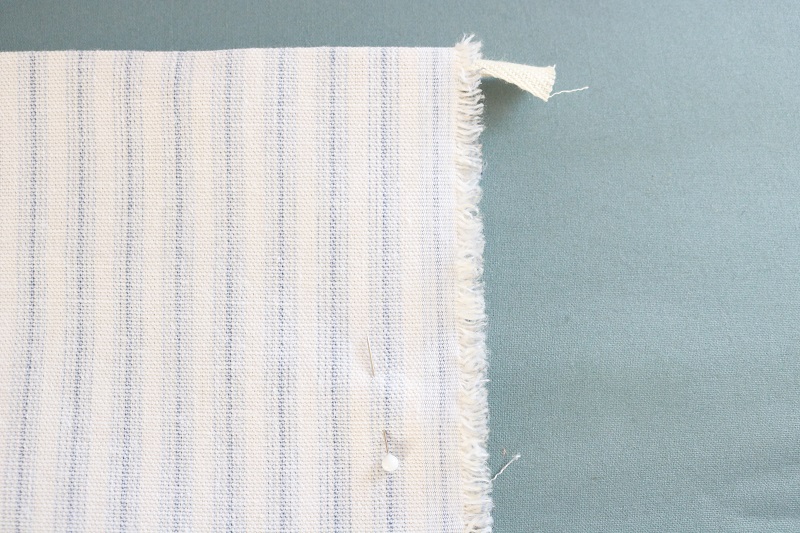 Farmhouse Style Pocket Apron - apron fabric folded in half with ribbon underneath