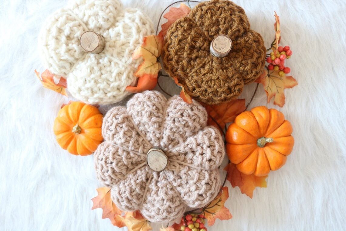 knit pumpkins displayed with real pumpkins