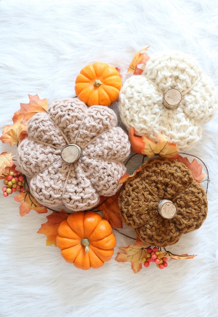 knit pumpkins displayed with real pumpkins and leaves