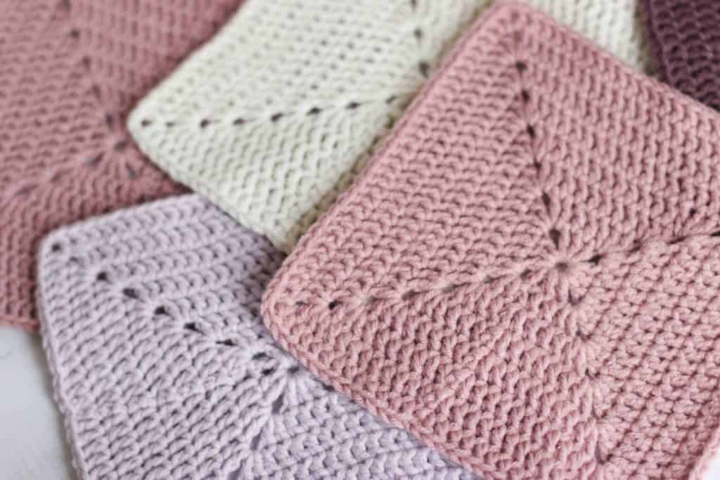 4 pastel solid crochet granny squares on table