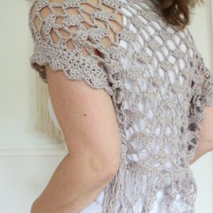 Seashell crochet shrug worn over a tank top, back view