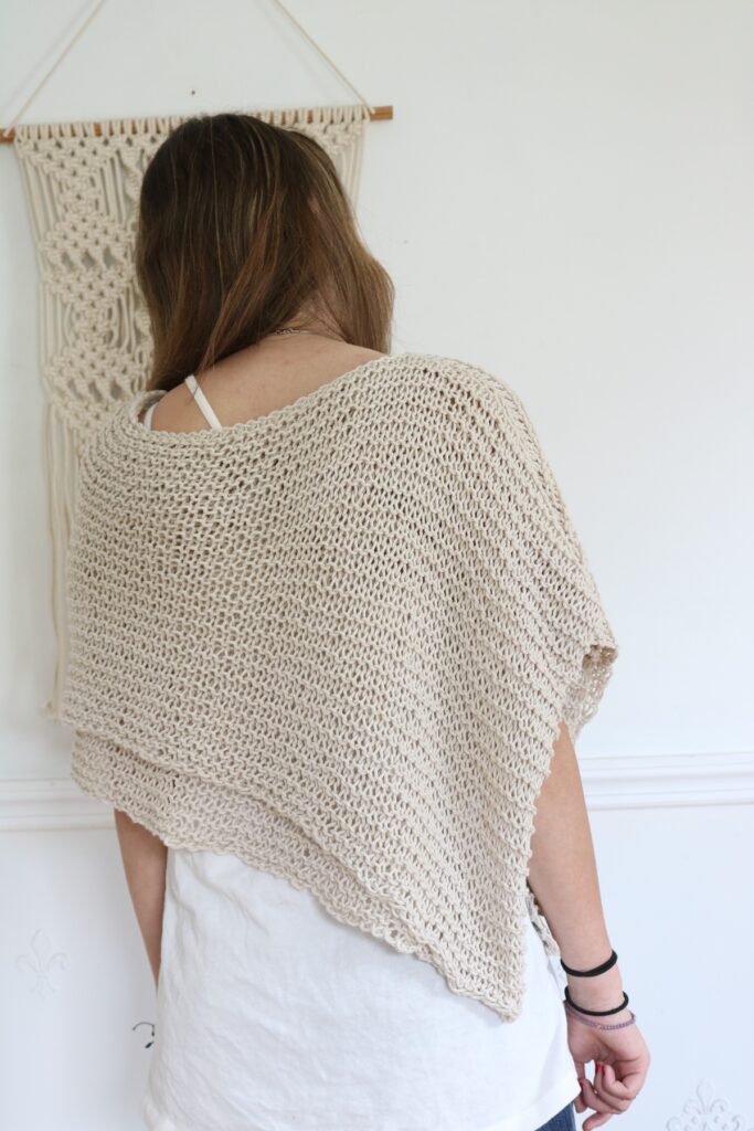 back of woman wearing knit cotton poncho 
