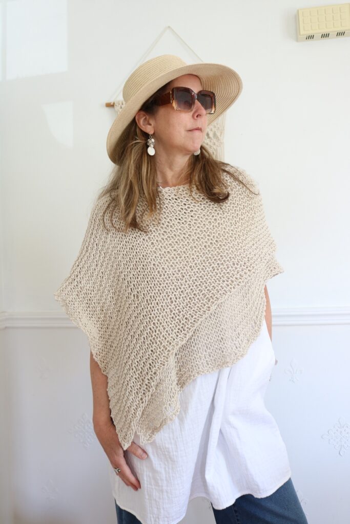 woman wearing knit cotton poncho and hat for summer