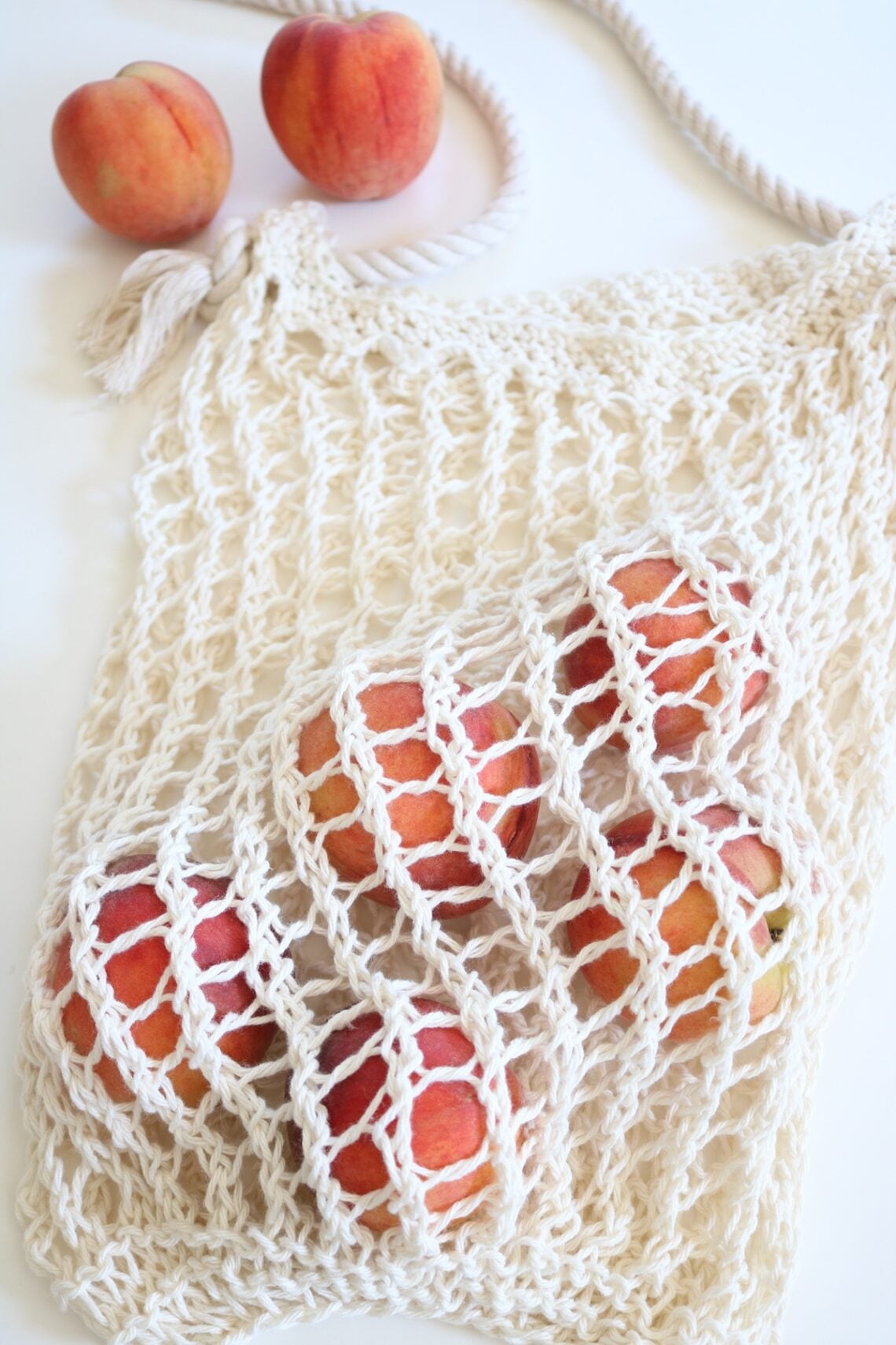 knit market bag on table with peaches