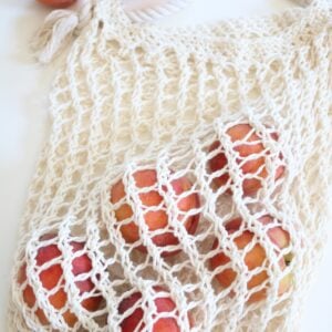 knit market bag on table with peaches