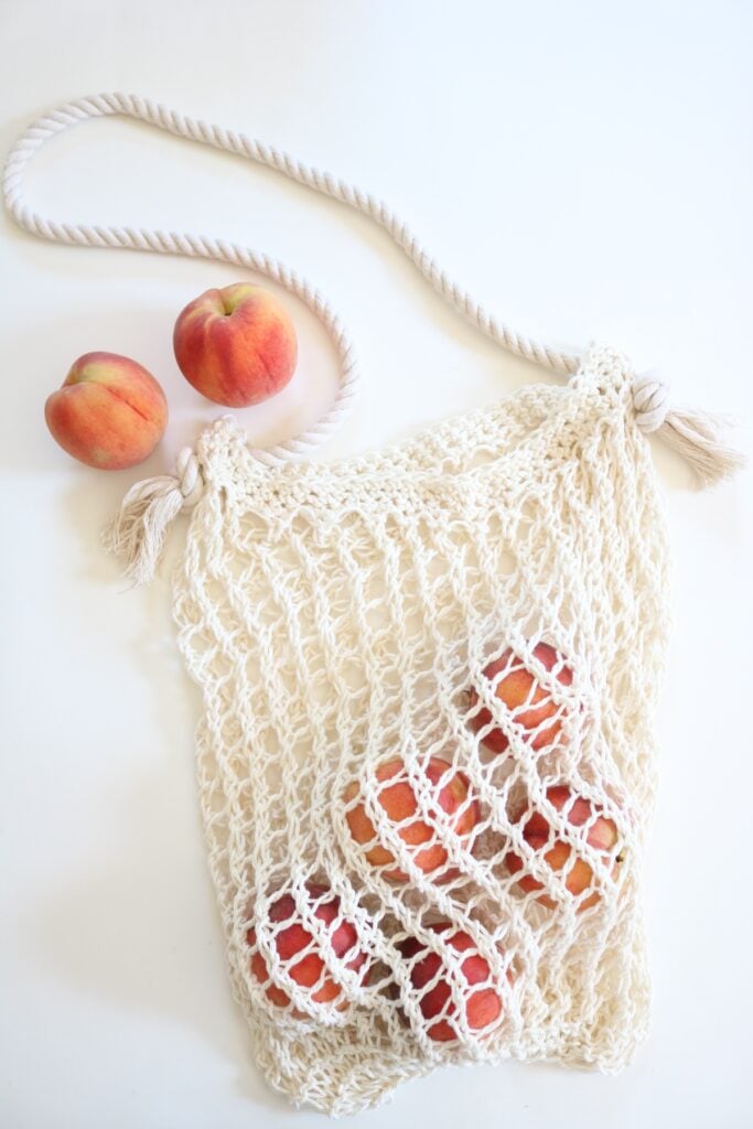 knit market bag on table with peaches