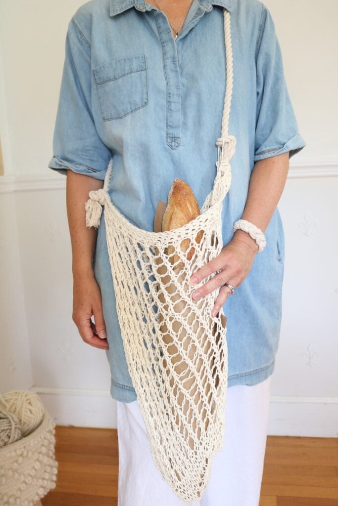 woman holding knit market bag